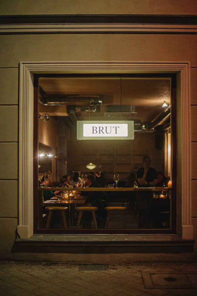 Brut Bistro i Gdańsk sett genom fönstret på kvällen med varmt ljus inifrån
